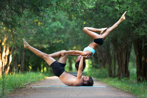 Canvas Acro yoga, two sporty people practice yoga in pair, couple doing stretching exer