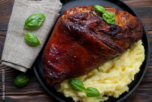 Top view of roasted pork knuckle with potato puree, close-up