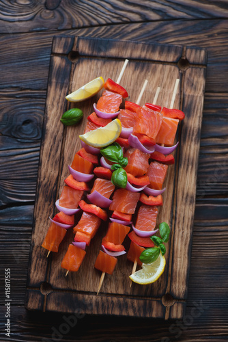 Above view of a rustic serving board with smoked trout kabobs
