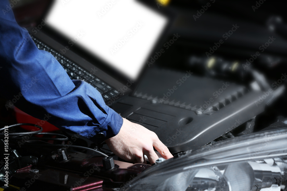 Professional auto mechanic working in repairing service, close-up. Car diagnostics concept