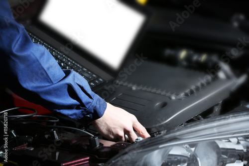 Professional auto mechanic working in repairing service, close-up. Car diagnostics concept