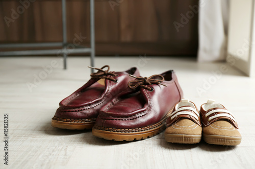Big and small shoes on wooden floor