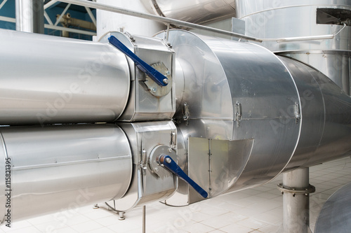 Photo of industrial looking pipes located at eye level with valves.