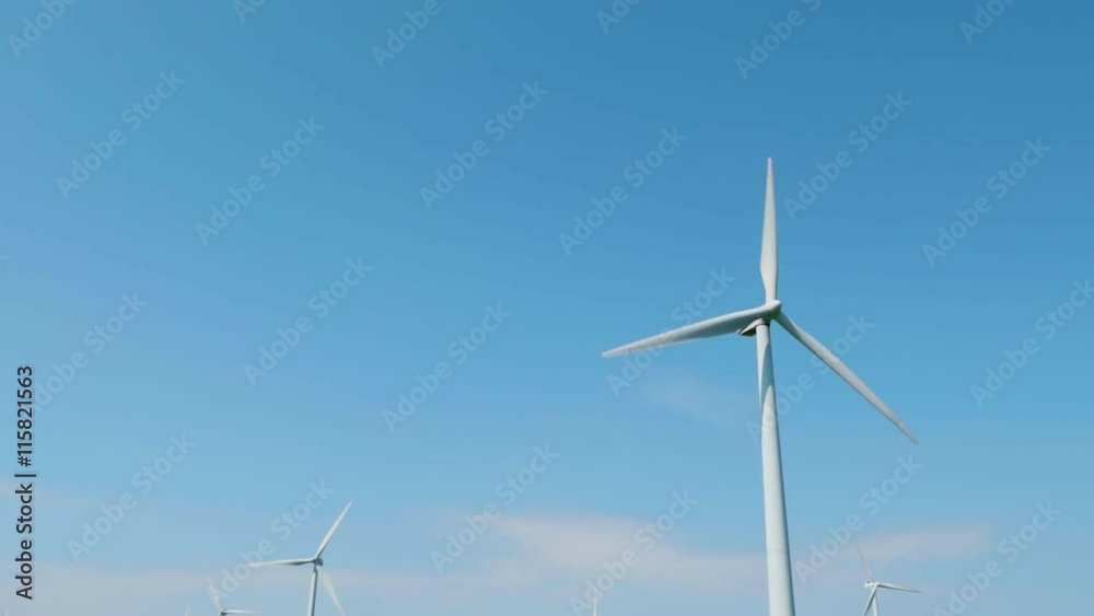 Camera tilts down from blue sky to windmills in the green field.
Camera tilts down from blue sky to windmills in the green field.