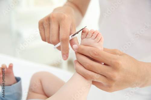 Mother cutting kids nails