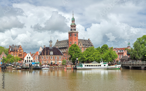 Leer, Germany. View from Leda river on the City Hall in Dutch Renaissance style, the Old Weigh House in Dutch classical Baroque style and the Tourist Harbor with historical boats.