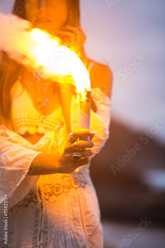 Girl holding a fire torch in the beach