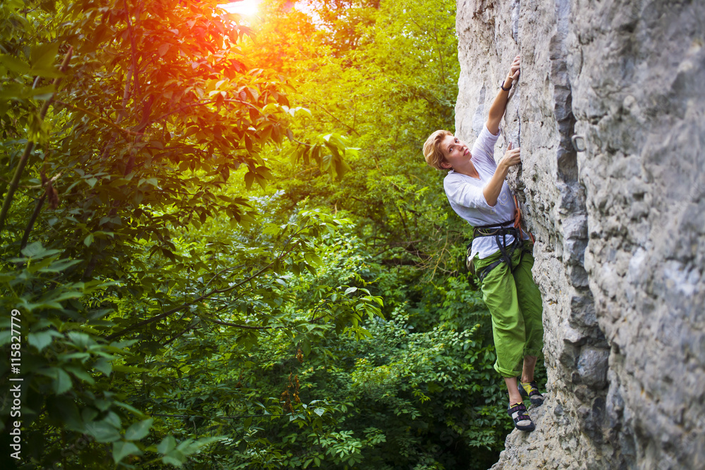 Fototapeta premium The girl climbs the rock.