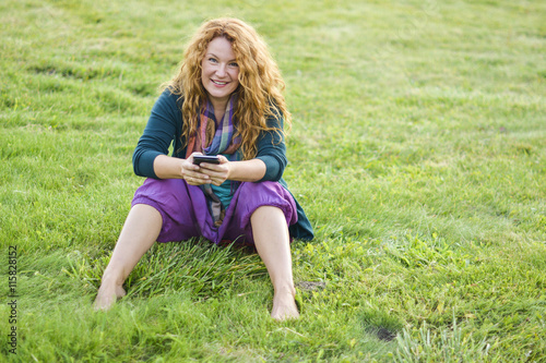 woman talking on phone top of the grass