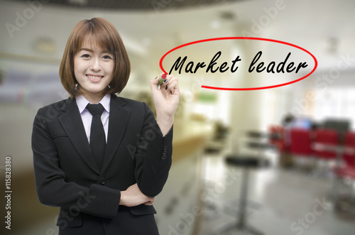 Businesswomen hand writing Market leader with black marker on visual screen. Isolated on background. Business, technology, internet concept. photo