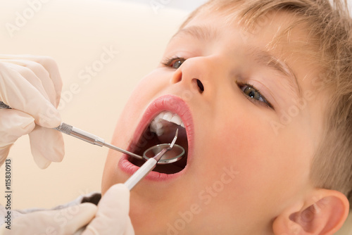 Dentist s Hand Examining Teeth Of Child Patient