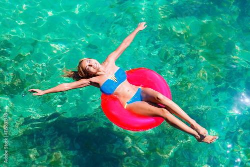 Happy beautiful young girl in bikini on a tropical beach. Blue s