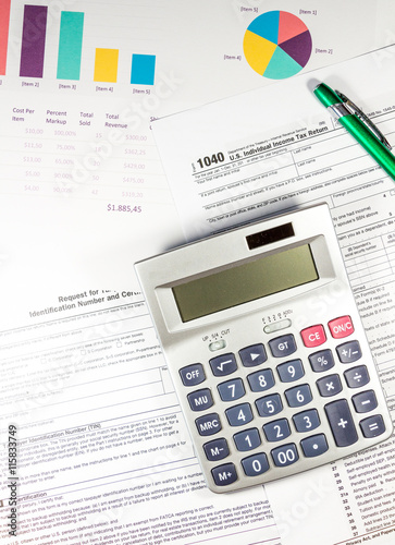 Calculating numbers for income tax return with pen and calculator