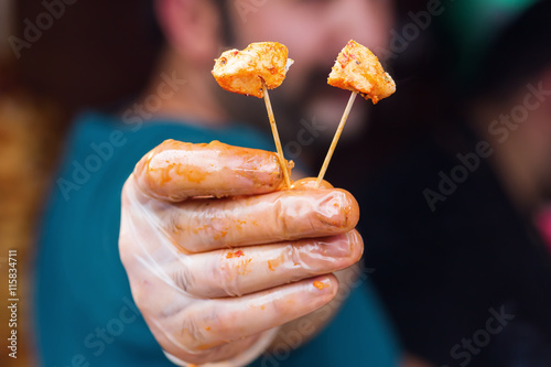 man holding a sample of fried meat