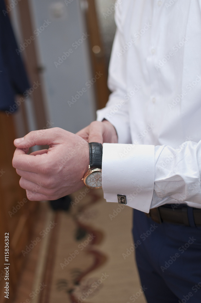 Obraz premium A man is putting up its watch 