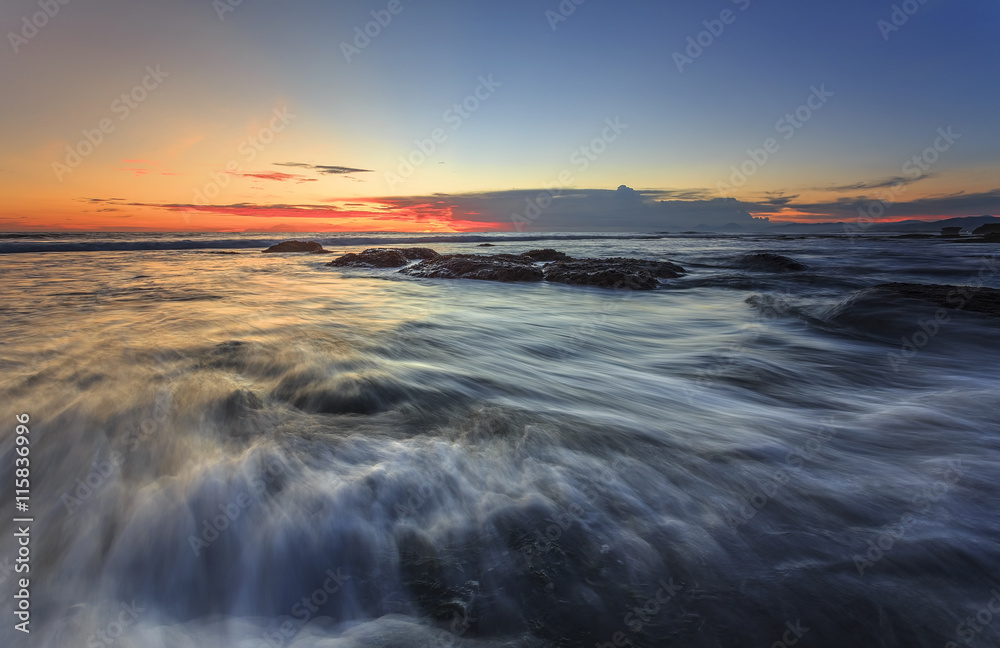 Waves of Tanah Lot beach at evening in bali indonesia