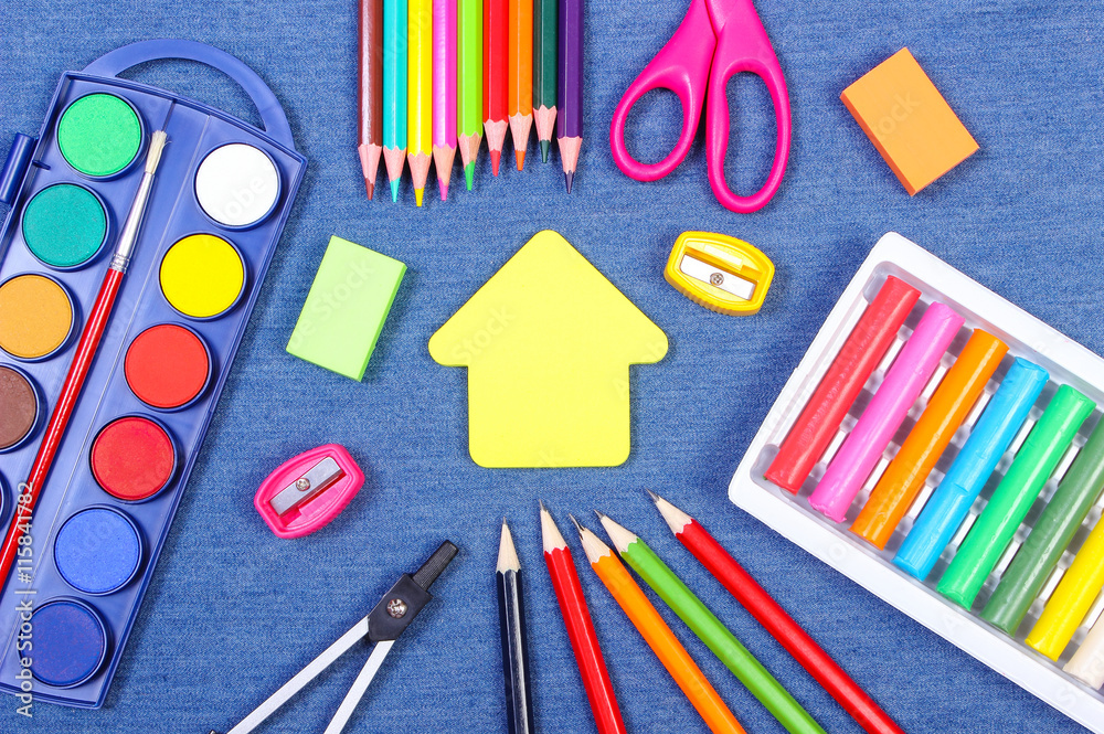 School supplies and shape of building on jeans background, back to school concept