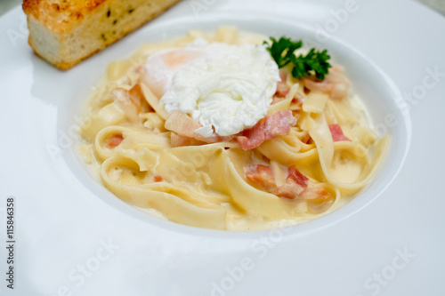 Carbonara Spaghetti with bacon and egg on white plate