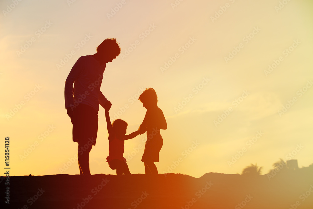 father with son and daughter silhouettes play at sunset father with son and daughter silhouettes play at sunset