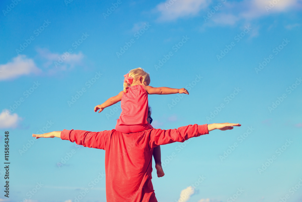 father and daughter on shoulders play at sky father and daughter on shoulders play at sky