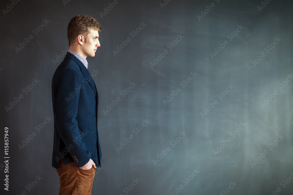 Profile of handsome man standing against grey wall background