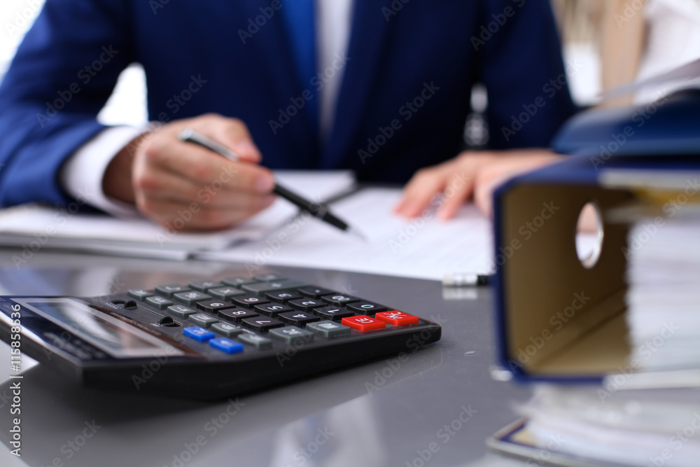 Φωτογραφία Binders with papers are waiting to be processed with businessman and secretary back in blur