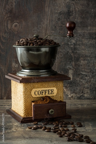 Coffee grinder and coffee beans on rustic wood