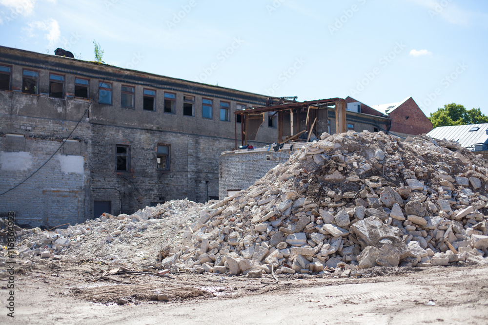 Construction site with an abandoned house and piles of demolition rubble