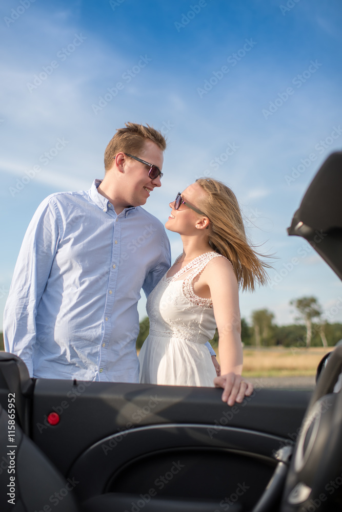 Liebespaar schaut sich in die Augen - Pärchen steht draussen am Auto 