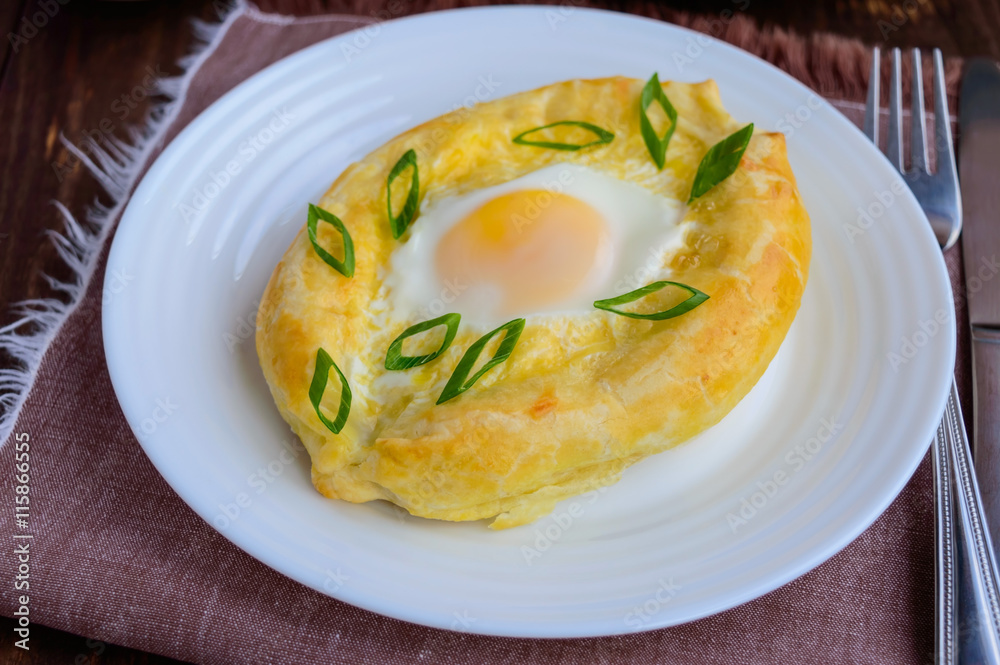 Khachapuri in Adjara (flat cakes with different fillings in the form of a boat) - the national dish of Georgian cuisine. Khachapuri in Adjara (flat cakes with different fillings in the form of a boat) - the national dish of Georgian cuisine.
