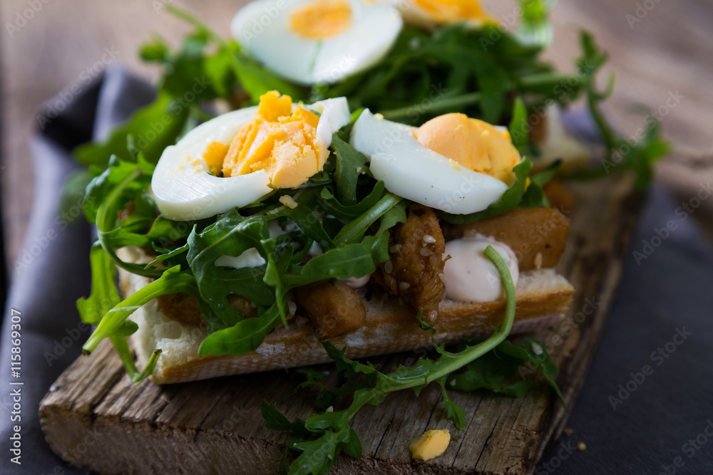 sandwich with meat, egg and arugula