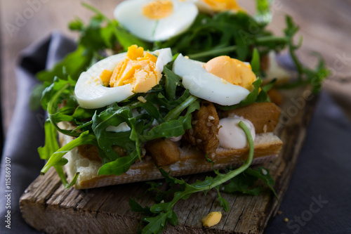 sandwich with meat, egg and arugula