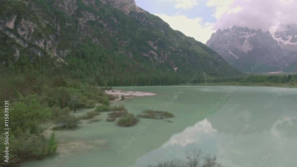 Drone aerial flying over a beautiful mountain lake Landro in Dolomites Alps, Italy