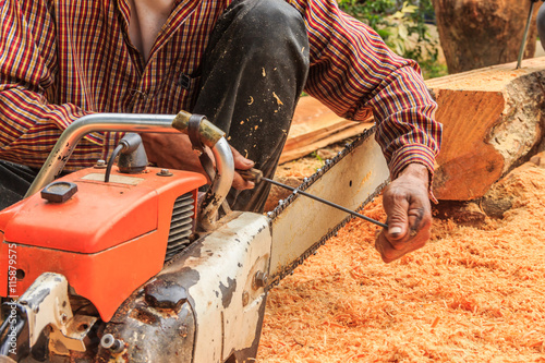 Man sitting filings chainsaw blade