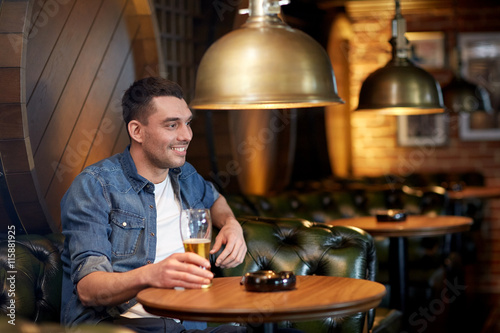 happy man drinking draft beer at bar or pub