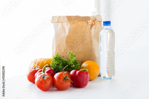 close up of paper bag with vegetables and water