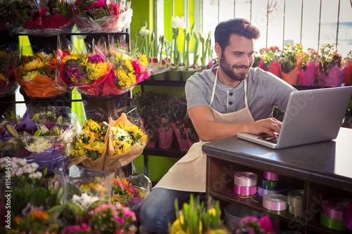 Male florist using laptop