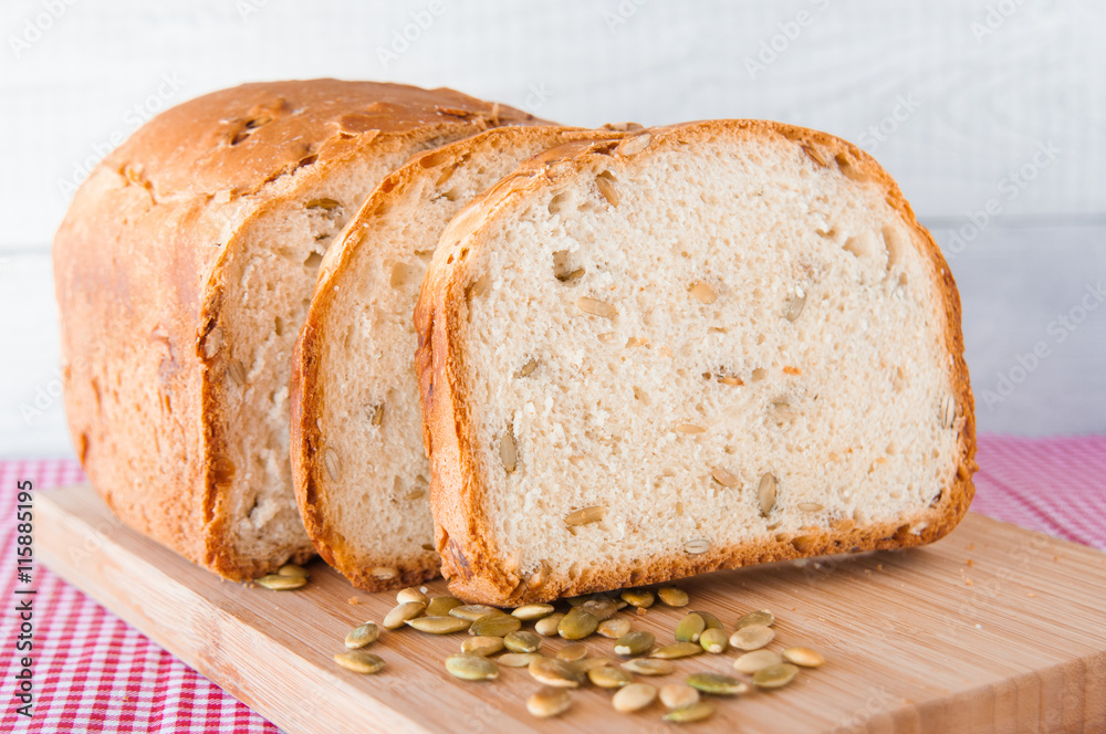 Loaf of white bread with green pumpkin seeds