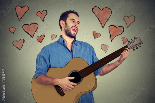 Portrait handsome musician young man in love playing guitar and singing a song