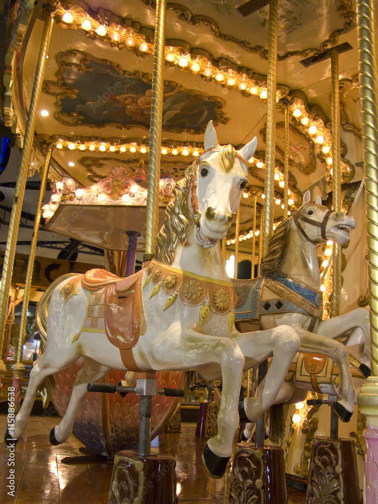 An old fashioned carousel at night. Detail of two horses