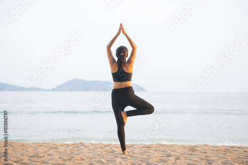 female practicing yoga on the beach