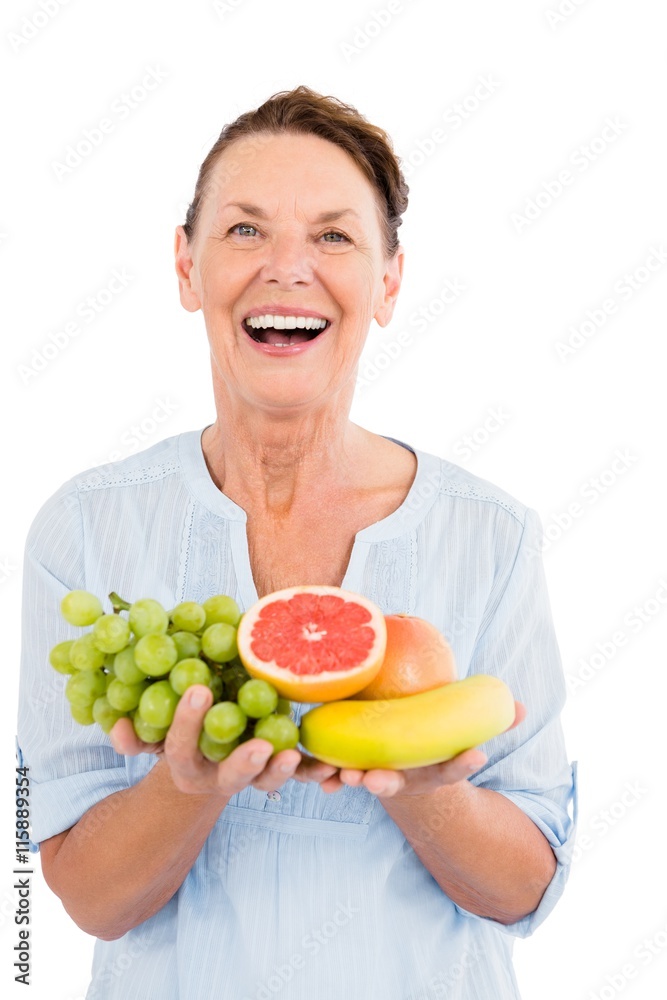 Portrait of happy mature woman holding fruits Portrait of happy mature woman holding fruits