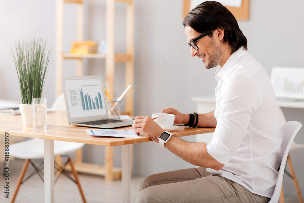 Pleasant smiling man sitting at the table Pleasant smiling man sitting at the table