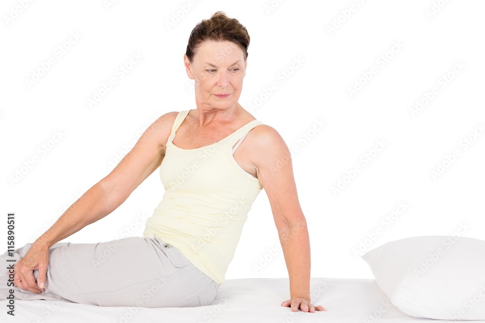 Confident mature woman exercising on bed Confident mature woman exercising on bed