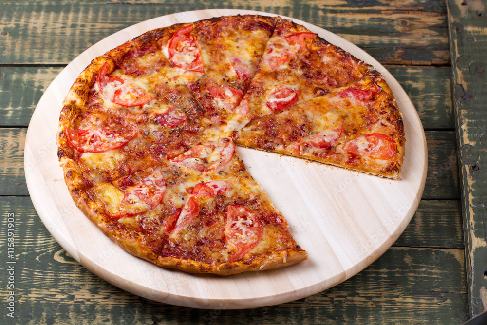 Delicious sliced margarita pizza on a table. Delicious sliced margarita pizza on a table.