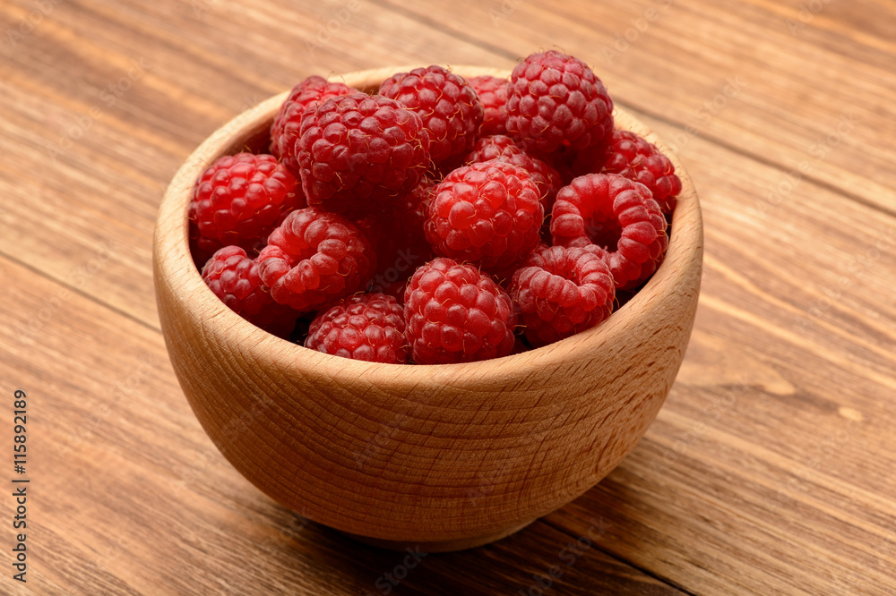 Ripe raspberries in wooden bowl. Close-up. Ripe raspberries in wooden bowl. Close-up.