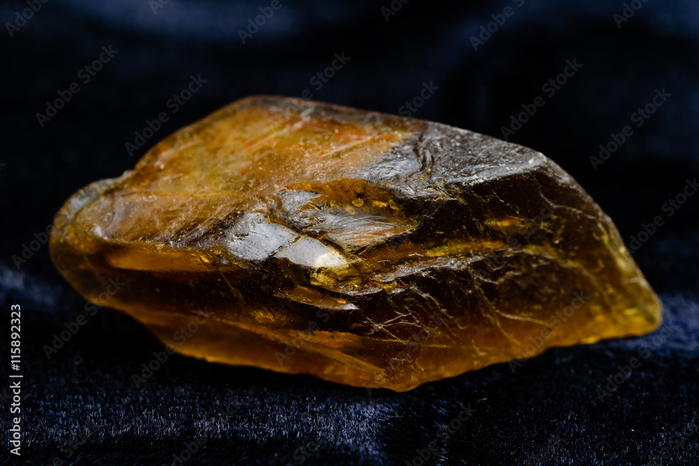 Lovely orange brown Amphibole crystal on black textile.