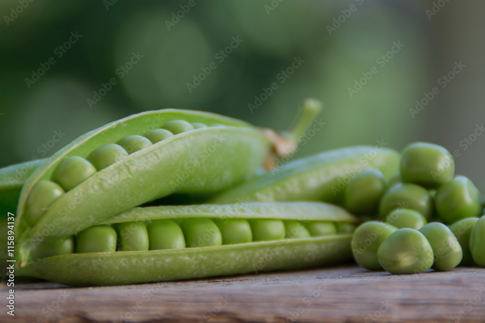 Fresh green pea pod on blurred background and wooden table. Beautiful bokeh Fresh green pea pod on blurred background and wooden table. Beautiful bokeh
