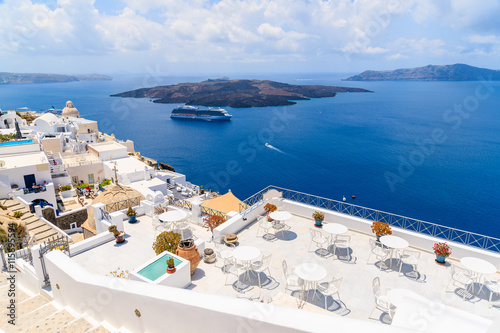 Terrace with white chairs and table in Firostefani village with caldera sea view, Santorini island, Greece