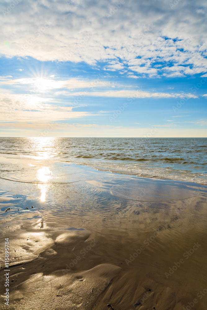 Sun shining over sea on Leba beach, Baltic Sea, Poland
